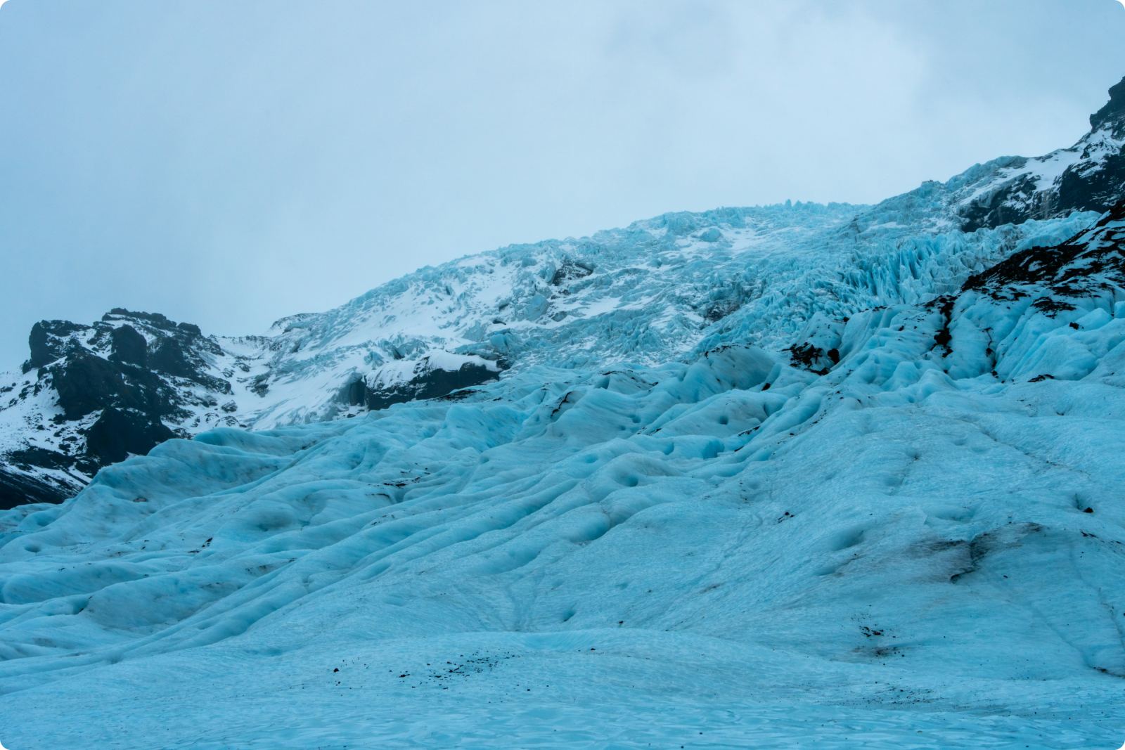 Blue glacier ice below a dark ridge on Vatnajökull.